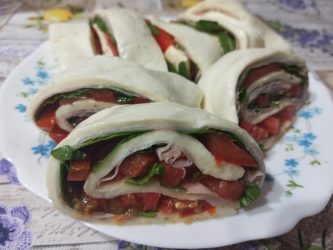 Rotolo di mozzarella farcito con prosciutto cotto e pomodori